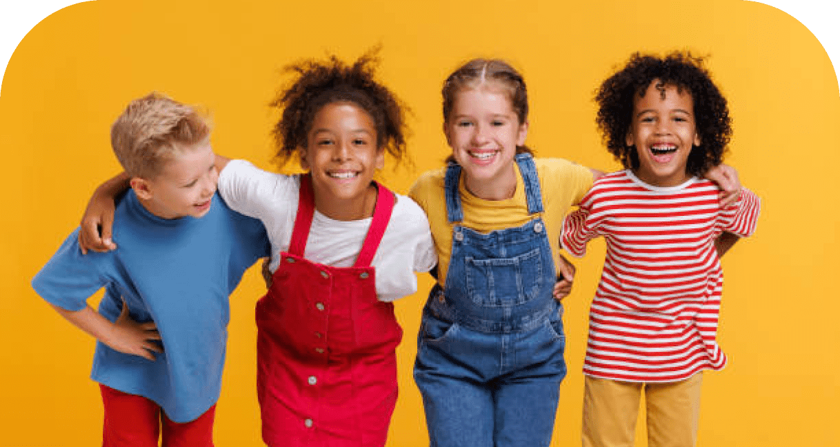 Four children standing together and smiling against a yellow background