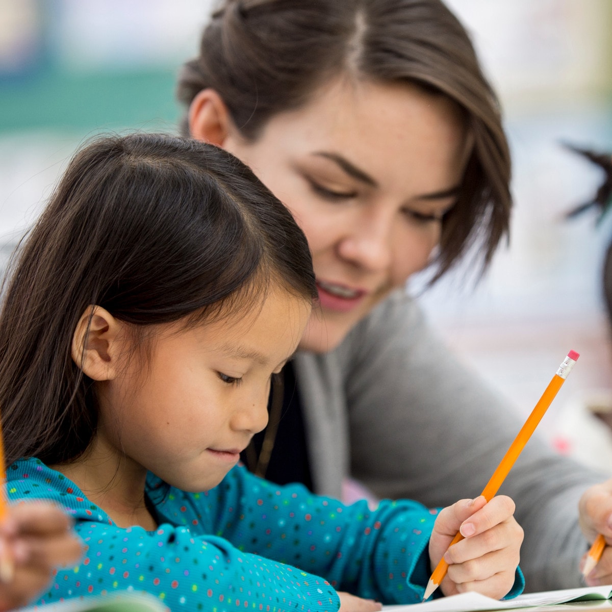 Teacher helping a child write