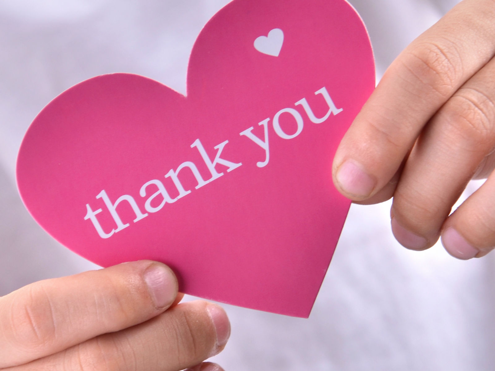 Child holding a thank you heart